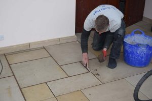 A valley installer working on tiled floor of summer house